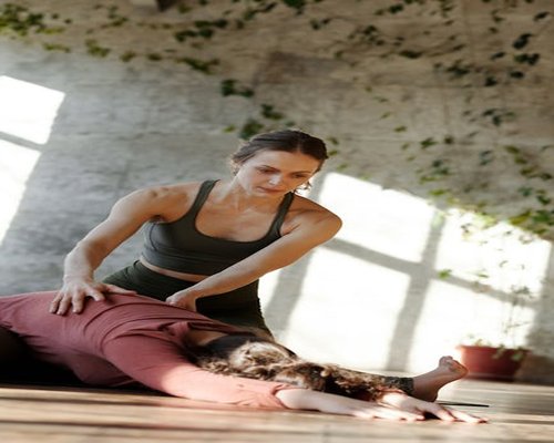 Person doing yoga stretches in a living room with sunlight